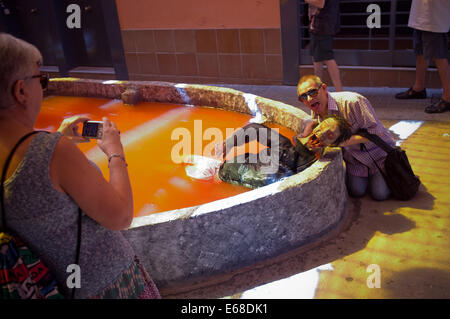 Barcelone, Espagne. 18 août, 2014. Les gens prennent des photos avec un zombie dans le quartier de Gracia de Barcelone. Progres Street, dans le quartier Gracia de Barcelone, a été personnalisé comme un zombie monde parce que de la traditionnelle fête d'été Festes de Gracia, le plus populaire dans la ville catalane. Crédit : Jordi Boixareu/Alamy Live News Banque D'Images