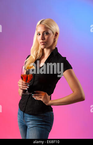 Belle Jeune Femme buvant aperol spritz isolé sur fond coloré Banque D'Images