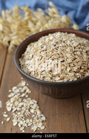 Oatflakes dans un bol sur fond de bois Banque D'Images