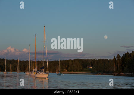 Harbour Centre, Brooklin, Maine - 9 août 2014. La presque pleine lune se levant au-dessus du centre Harbour au coucher du soleil. Banque D'Images