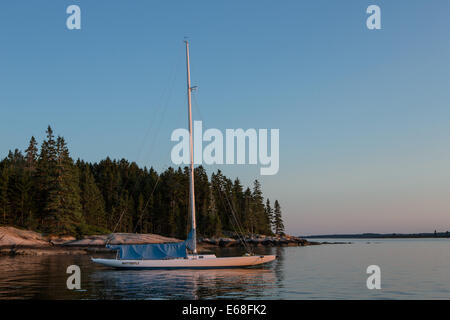 Harbour Centre, Brooklin, Maine - 9 août 2014. Papillon sloop à l'ancre au coucher du soleil. Banque D'Images