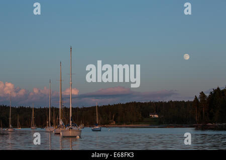 Harbour Centre, Brooklin, Maine - 9 août 2014. La presque pleine lune se levant au-dessus du centre Harbour au coucher du soleil. Banque D'Images