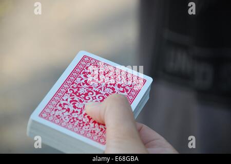 Un jeu de cartes à jouer, souvent utilisé dans les tours de magie, est tenu dans une main. Ces cartes sont généralement associées aux jeux de cartes et sont des outils essentiels pour les magiciens effectuant des tours de tour de tour de tour de tour. Banque D'Images