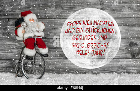 Carte de joyeux Noël en rouge et blanc avec texte allemand et un père noël. Banque D'Images