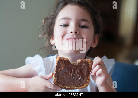 Enfant de manger du pain avec chocolat à tartiner Banque D'Images