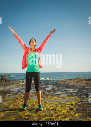 Caucasian runner stretching on beach Banque D'Images