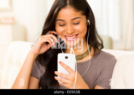 Hispanic woman listening to earphones Banque D'Images