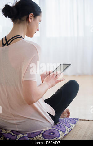 Caucasian woman using tablet computer in living room Banque D'Images