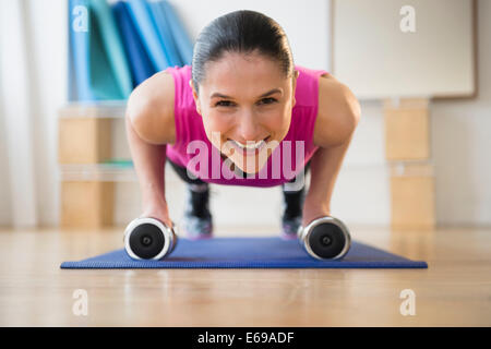 Caucasian woman faire poussez se lève on yoga mat Banque D'Images