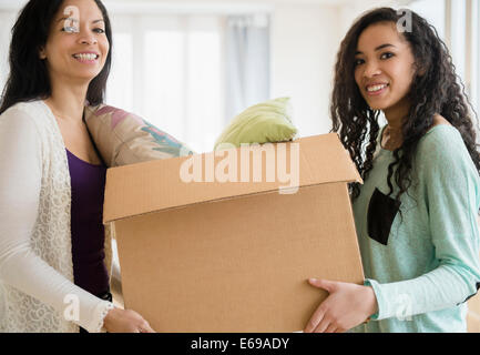 Mère et fille carrying cardboard box Banque D'Images