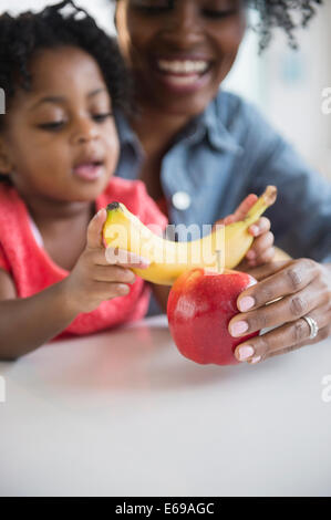 Mère et fille jouer avec des fruits Banque D'Images