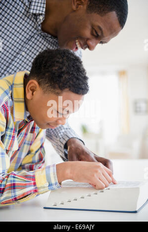 Father helping son dictionnaire de lecture Banque D'Images