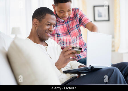 Père et fils font des achats en ligne Banque D'Images