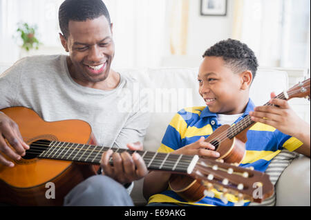Père et fils jouant de la musique ensemble Banque D'Images