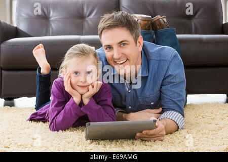 Caucasian father and daughter using tablet computer in living room Banque D'Images