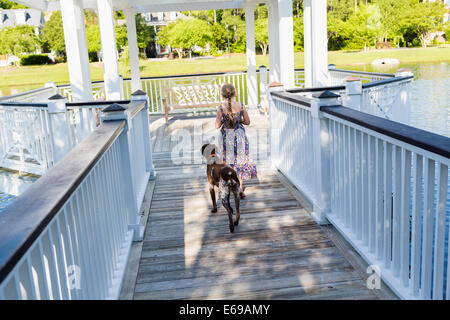 Caucasian girl walking with dog in gazebo Banque D'Images