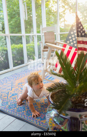 Caucasian baby crawling on porch Banque D'Images