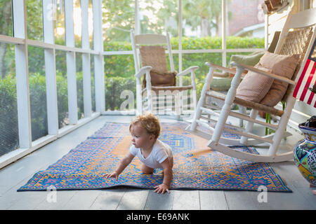 Caucasian baby crawling on porch Banque D'Images