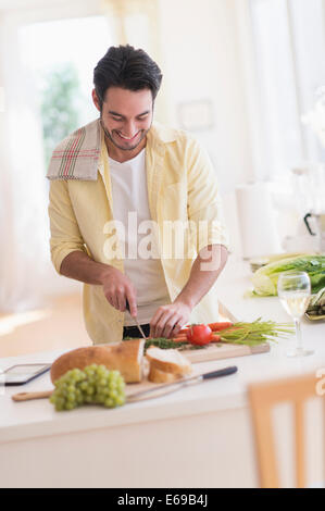 Mixed Race man cooking in kitchen Banque D'Images