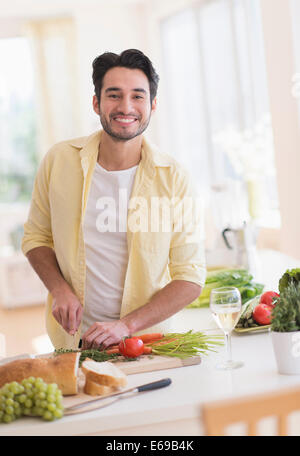 Mixed Race man cooking in kitchen Banque D'Images