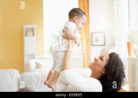 Mixed Race woman with baby sur canapé Banque D'Images