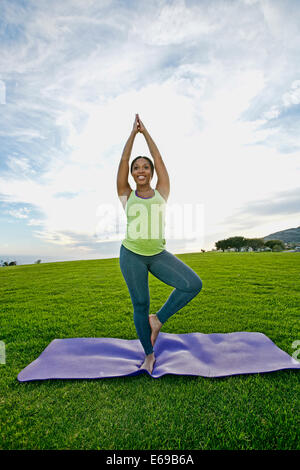 Pregnant woman practicing yoga in park Banque D'Images