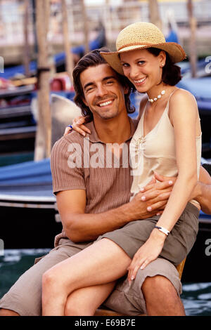 Couple assis près de gondoles, Venise, Vénétie, Italie Banque D'Images