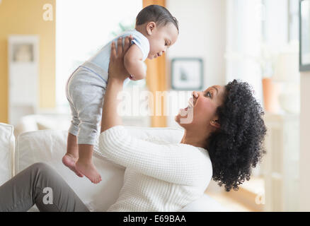 Mixed Race woman with baby sur canapé Banque D'Images