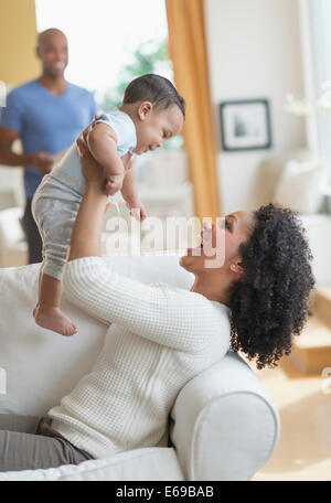 Mixed Race woman with baby sur canapé Banque D'Images