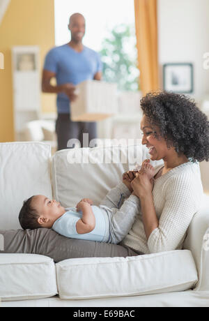 Mixed Race woman with baby sur canapé Banque D'Images