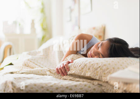 Mixed Race woman sleeping in bed Banque D'Images