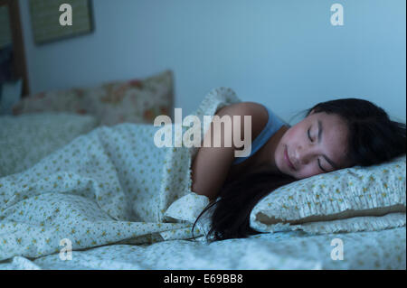 Mixed Race woman sleeping in bed Banque D'Images