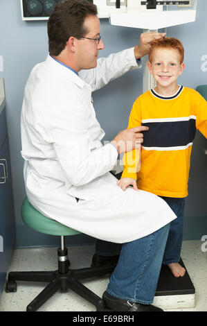 Mesurer la hauteur du garçon médecin in office Banque D'Images