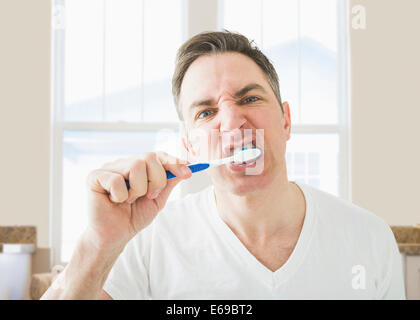 Caucasian se brosser les dents dans la salle de bains Banque D'Images