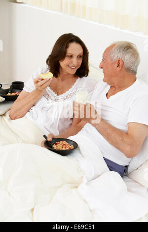 Senior couple eating breakfast in bed Banque D'Images