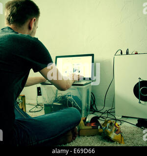 Caucasian man using laptop on floor Banque D'Images