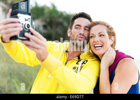 Caucasian couple taking self-portrait with vintage camera Banque D'Images