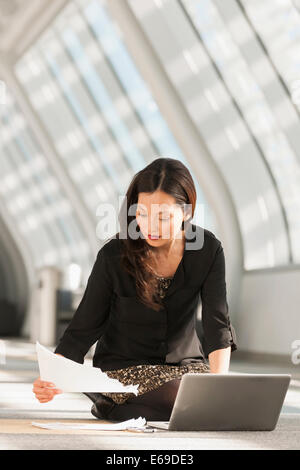 Japanese businesswoman using laptop à l'étage du lobby Banque D'Images