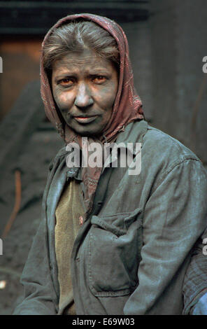 Un travailleur féminin à l'usine de noir de carbone dans la petite ville industrielle de Copsa Mica, Transylvanie couvert de poussière. Banque D'Images