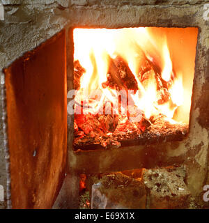Brûler du bois dans la région de four avec porte ouverte close up Banque D'Images