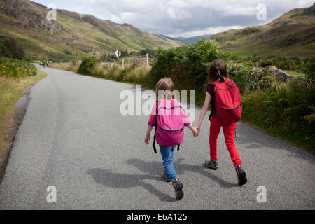 Deux enfants randonnées le long d'un chemin rural dans les Highlands écossais. Banque D'Images