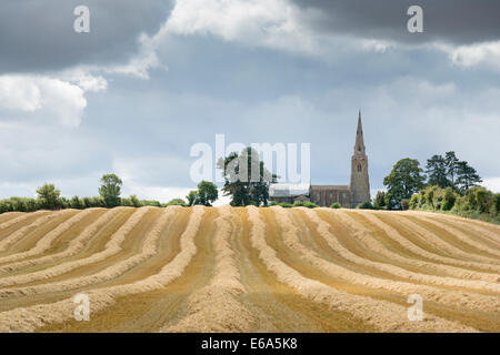 Little Staughton, Bedfordshire, Royaume-Uni. 19 août 2014. Des nuages sombres se rassemblent sur l'Eglise et les champs de blé fraîchement récoltés à Little Staughton en Amérique du Bedfordshire. Les températures en journée dans une grande partie de la France n'a pas réussi à atteindre les 20 degrés C pour la première fois depuis le début de juin. L'ensoleillement et d'une douche et d'un frisson dans l'air a donné un signe distinctif à l'automne météo. Credit : Julian Eales/Alamy Live News Banque D'Images