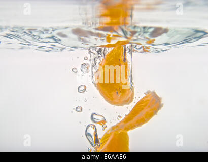 Être coincé Orange est tombé dans l'eau avec un fond blanc. Banque D'Images