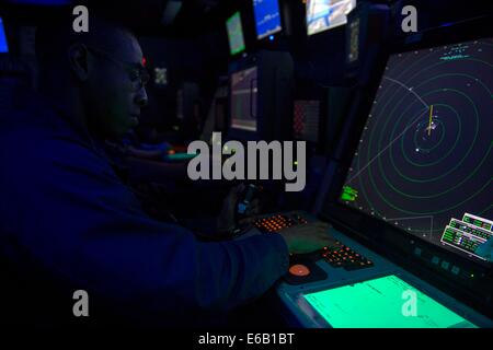 Contrôleur de la circulation aérienne de la Marine américaine 1ère classe Fernando Montes signifie regarder de contrôle d'approche dans le centre de contrôle du trafic aérien amphibie à bord du navire d'assaut amphibie récemment mis en service (LHA USS America 6) dans l'Océan Atlantique le 31 juillet 2014. L'Americ Banque D'Images