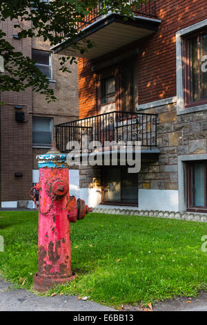 Vieux rouge d'incendie en face d'un bloc d'appartement Banque D'Images