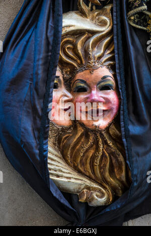 Un double fait face Soleil et lune masque de carnaval étendus dehors un atelier à Venise. Banque D'Images