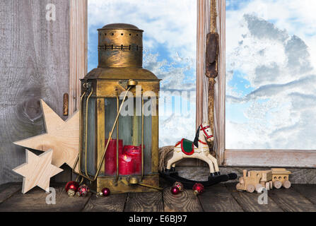Décoration de Noël vieille nostalgique avec de vieux jouets et une vieille lanterne avec des bougies sur le rebord de la fenêtre. Banque D'Images