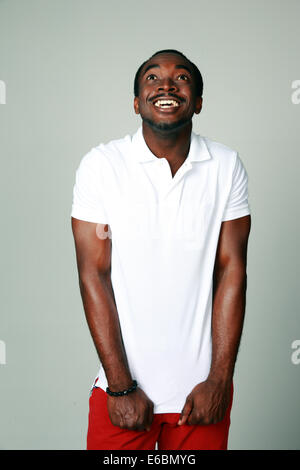 Funny african man looking up sur fond gris Banque D'Images