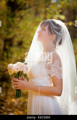 Belle Mariée avec bouquet de mariage dans le parc Banque D'Images