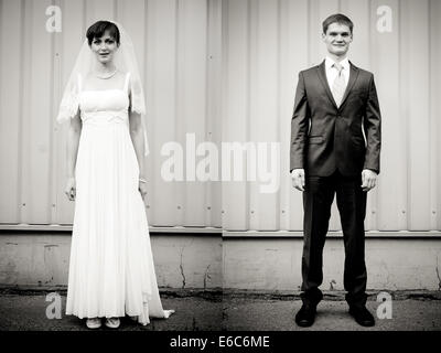 Full Length portrait of Bride and Groom standing against wall Banque D'Images